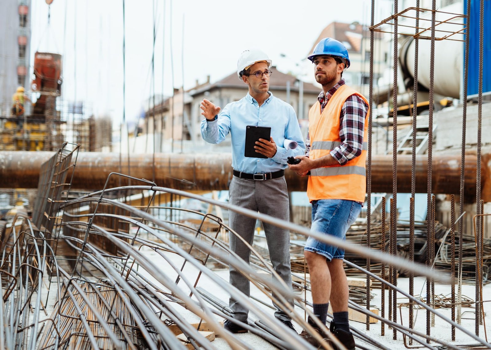Construction site with engineers reviewing progress, illustrating public-private partnership execution and federal facilities project oversight.